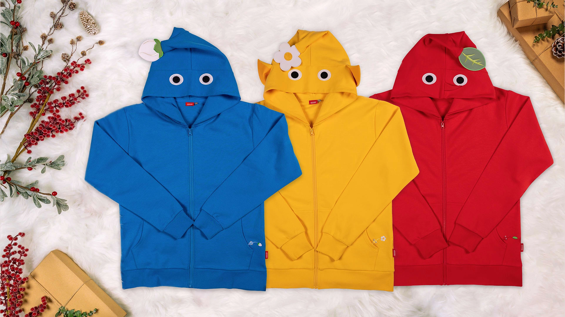 Cozy Pikmin hoodies in blue, yellow, and red, perfect for holiday shopping at Nintendo stores. Exclusive winter collection!