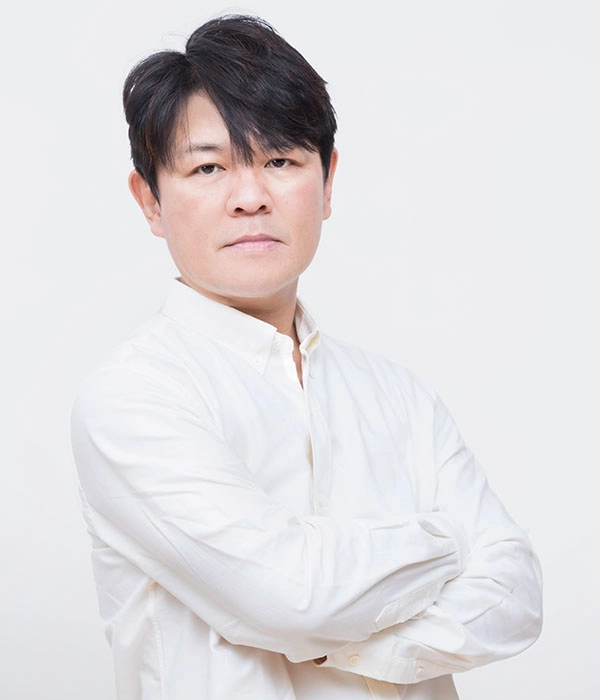 Person in white shirt posing confidently in a studio setting, relevant to PlayStation Partner Awards Japan/Asia event.