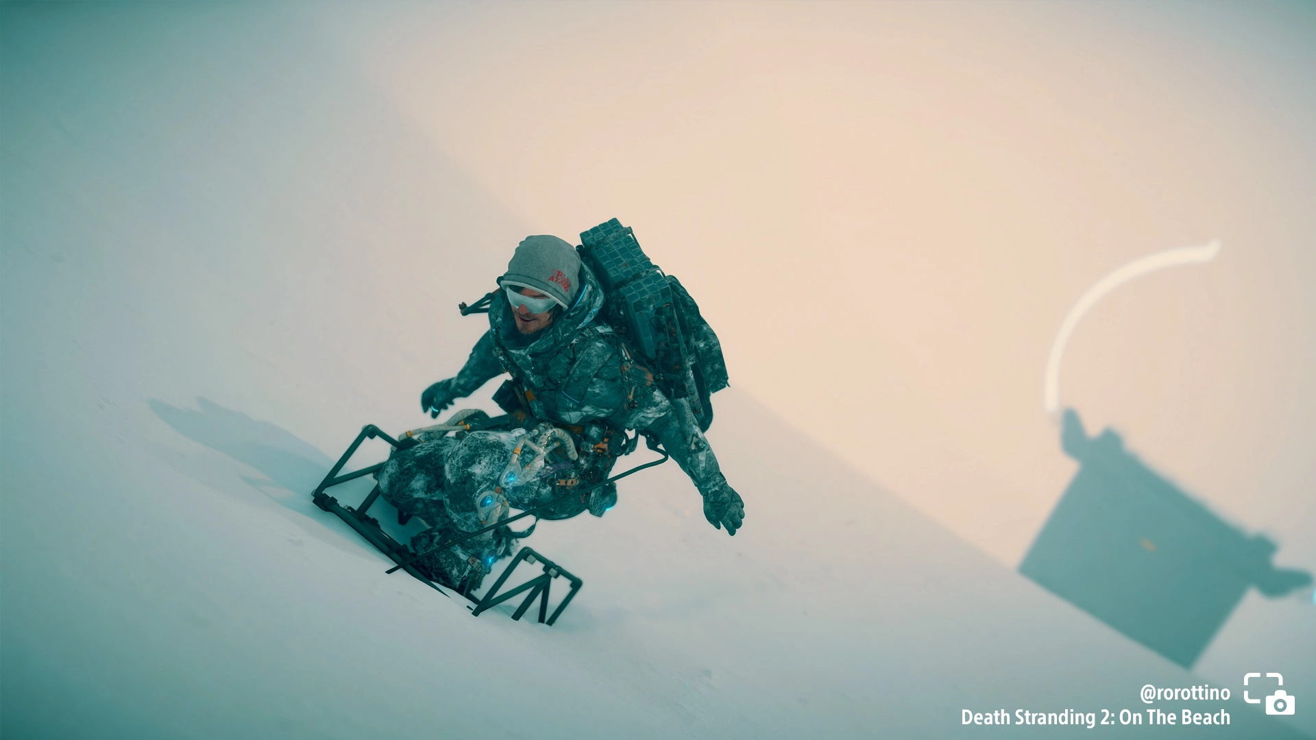 A character snowboards down a snowy slope in Death Stranding 2, showcasing a stunning winter landscape. #PSshare #PSBlog