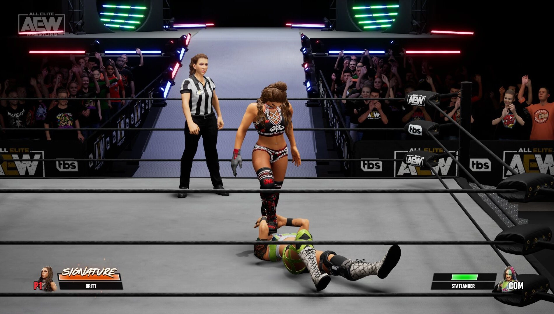 Wrestler standing over opponent in AEW ring, referee nearby, showcasing AEW: Fight Forever game action