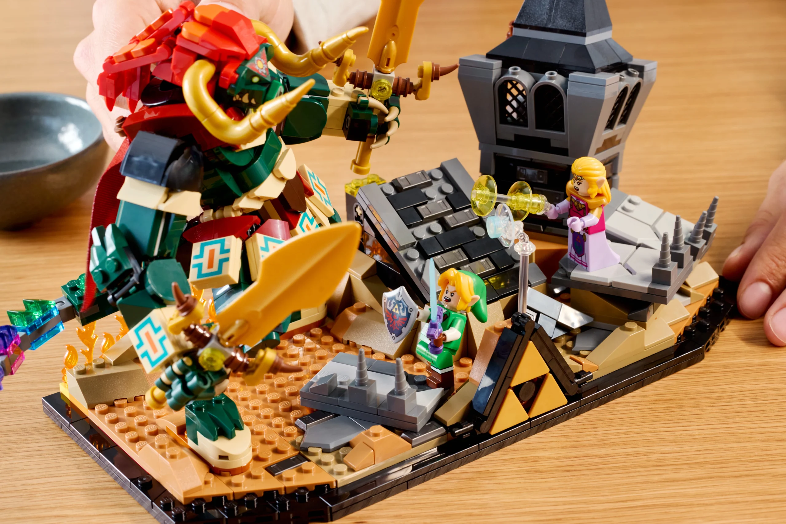 LEGO set depicting Link, Zelda, and Ganon in a battle scene from Ocarina of Time, with castle ruins and weapons