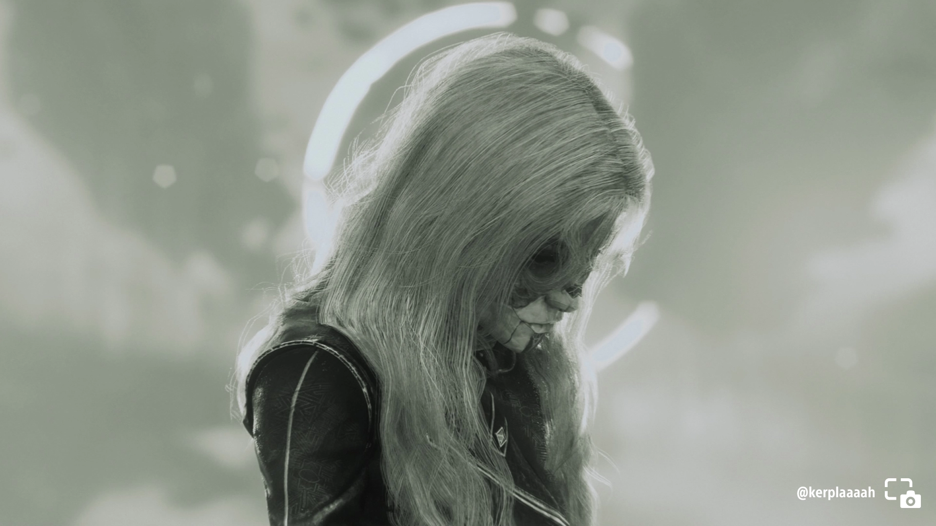 Alicia looking downcast in a black and white portrait, with a soft glow in the background