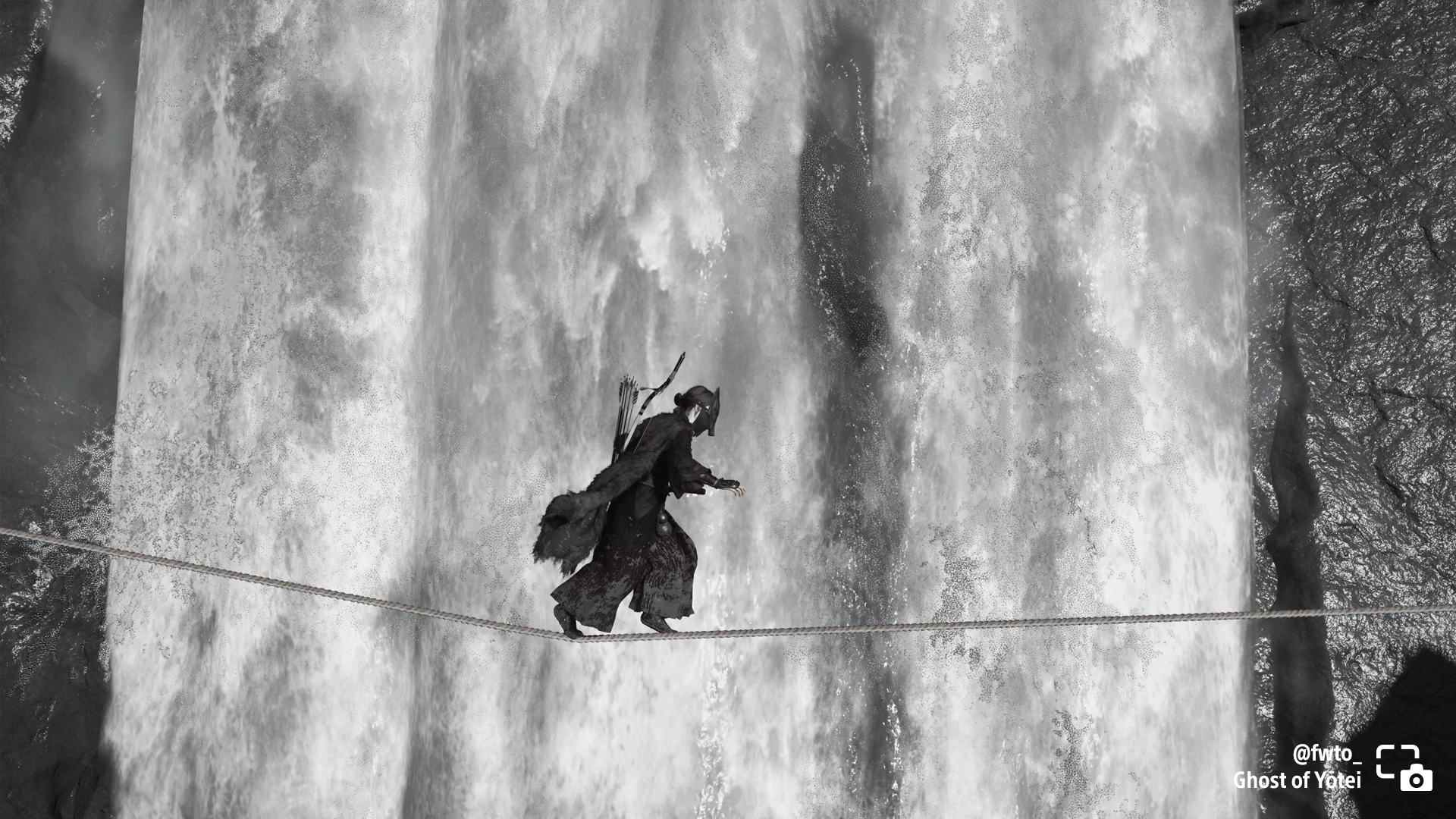 A black and white shot of Atsu crossing a rope near a waterfall in Ghost of Yōtei, capturing a thrilling gaming moment.