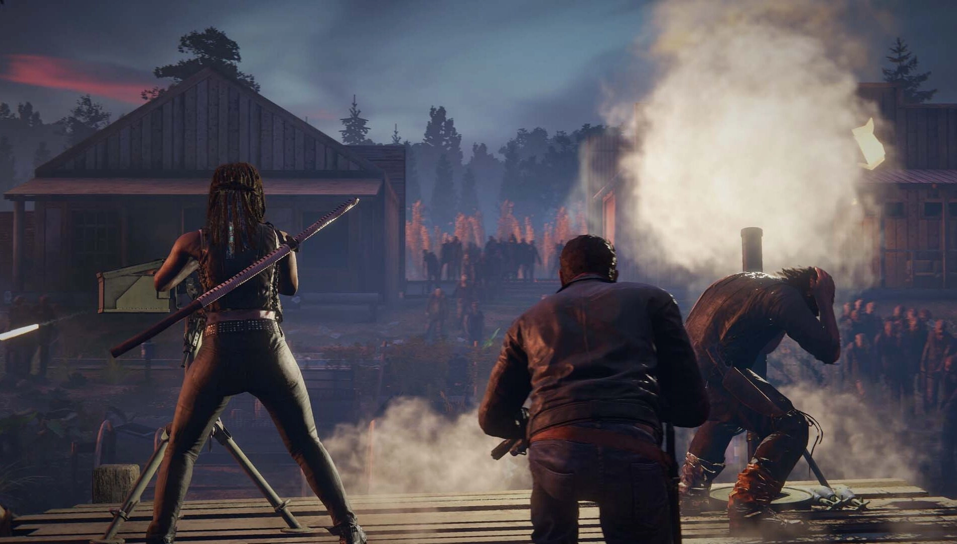 Survivors battle zombies in a fiery, overrun settlement, capturing the intense crossover atmosphere