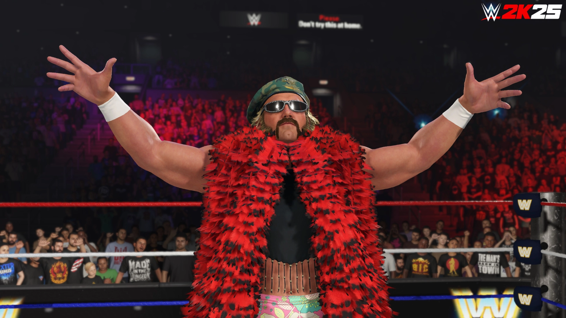 Wrestler in a vibrant red feathered robe and sunglasses poses confidently in a WWE 2K25 ring