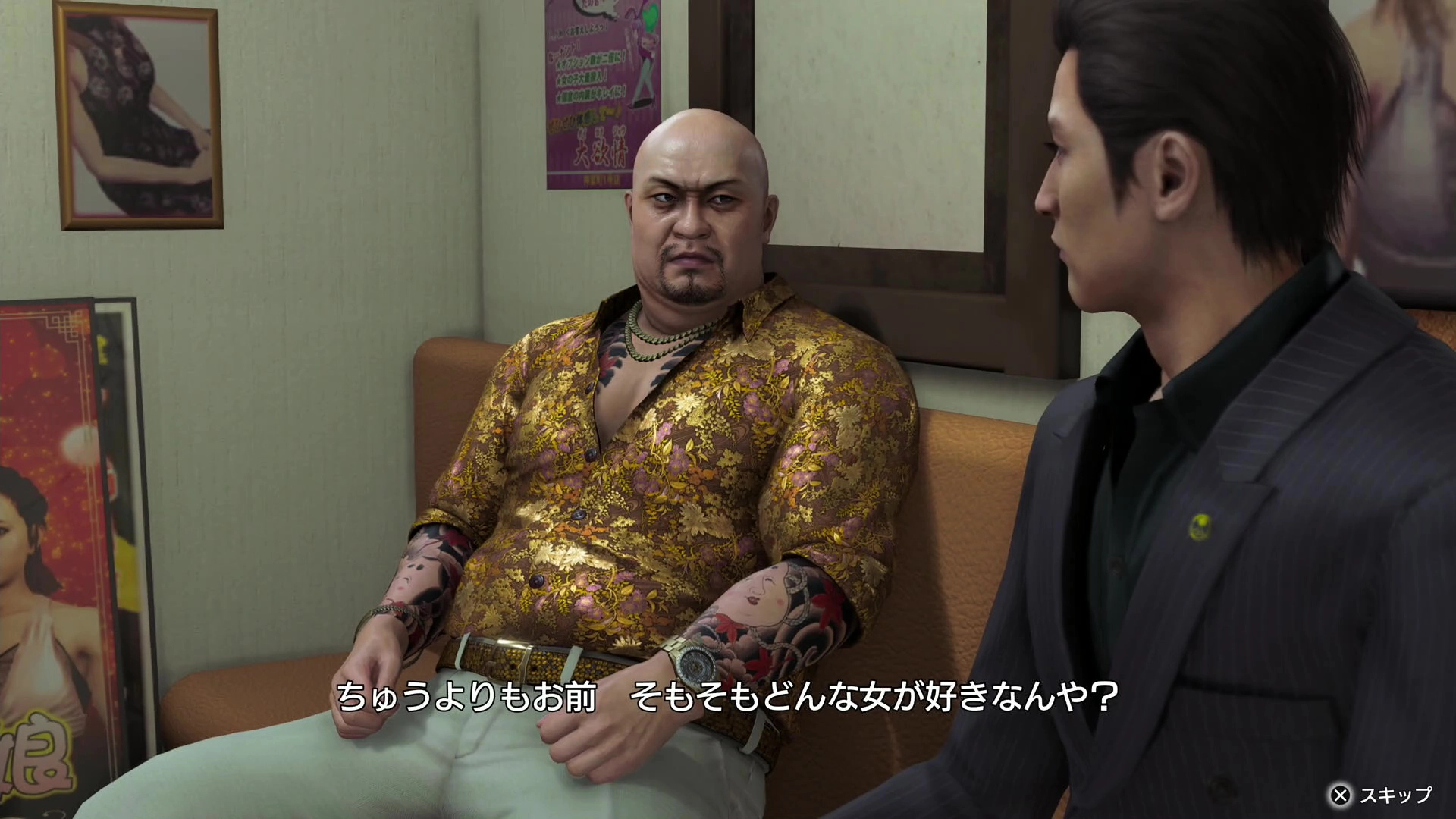 Two men in a tense conversation on a couch, one in a floral shirt, from Yakuza Kiwami 3 game scene