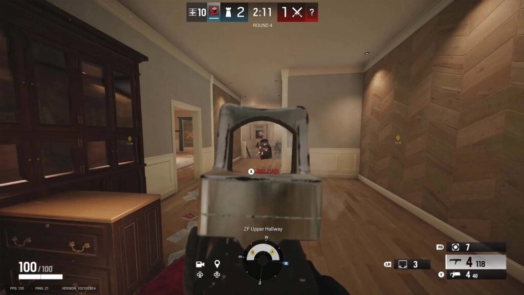 First-person view in Rainbow Six Siege, aiming down sights in a hallway during a tense match round