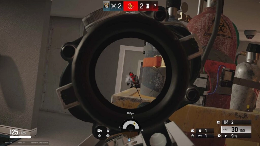 First-person view through a sniper scope in Rainbow Six Siege, targeting an opponent in a gym setting