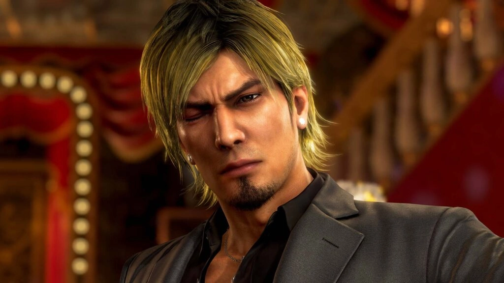 A character with blond hair and a serious expression, set in a richly decorated room with red curtains