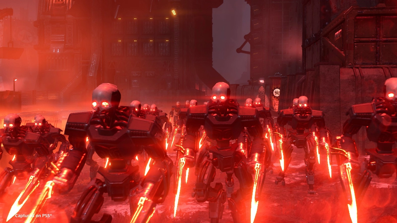 Cyborgs with glowing red eyes and weapons march through Cyberstan's industrial cityscape at night