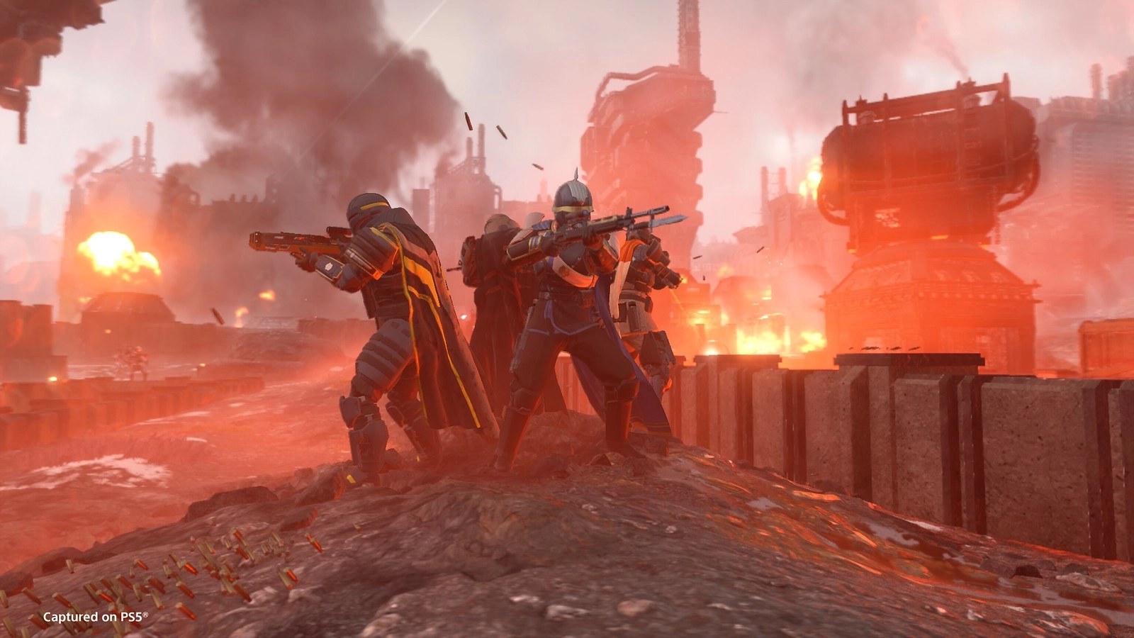 Helldivers in battle gear stand ready amidst fiery industrial ruins, preparing to fight Cyborg forces in Cyberstan