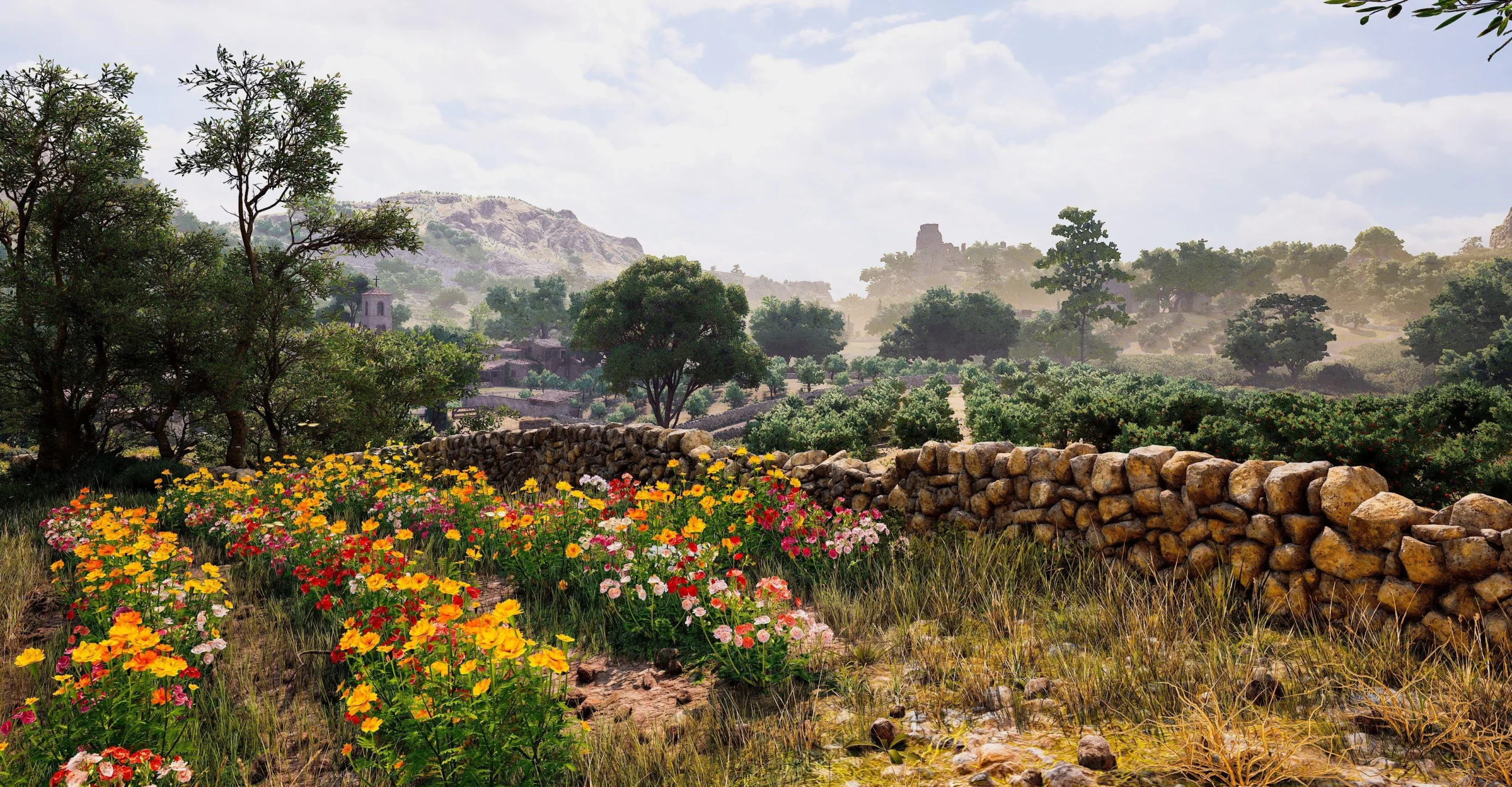 Vibrant wildflowers bloom beside a stone wall in Valle Dorata, with hills and trees in the background