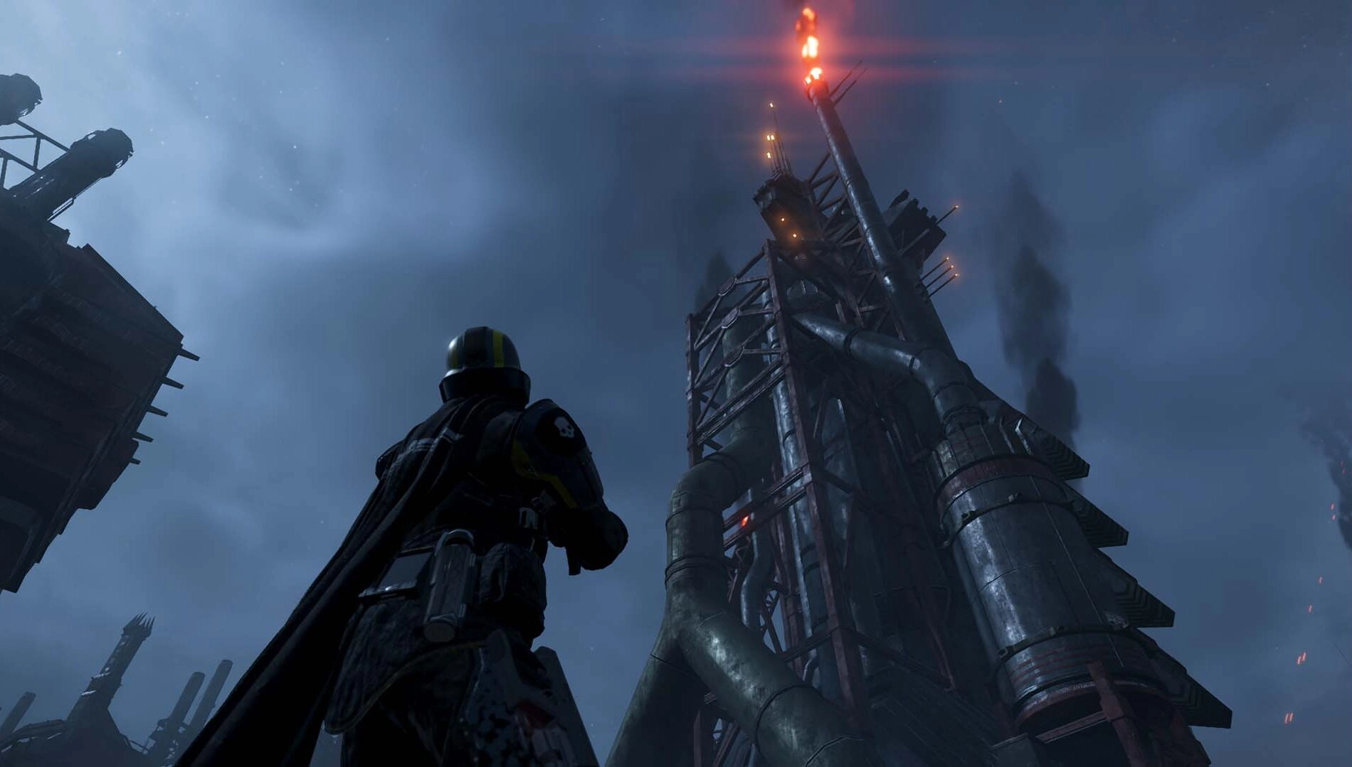A Helldiver gazes at a towering industrial structure on Cyberstan, under a dark, ominous sky