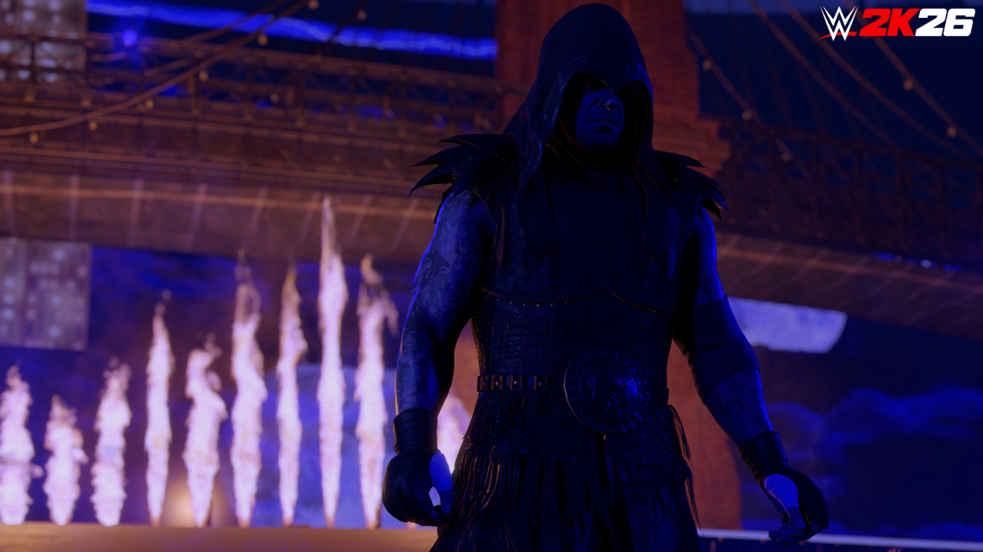 A mysterious wrestler in dark attire stands under dramatic lighting, with flames and a bridge in the background