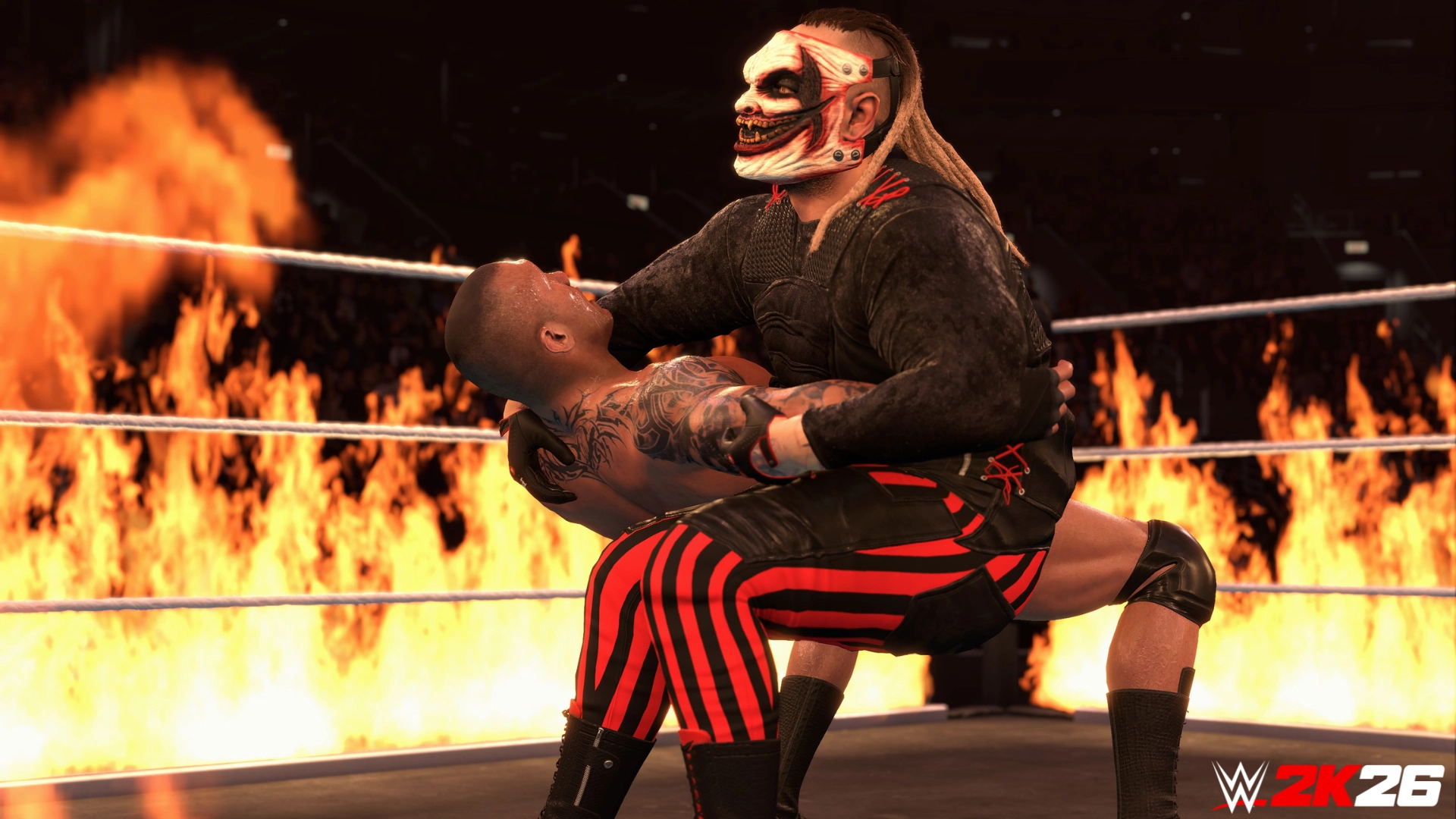 Two wrestlers in a fiery WWE 2K26 ring, one in a mask holding the other in a dramatic pose